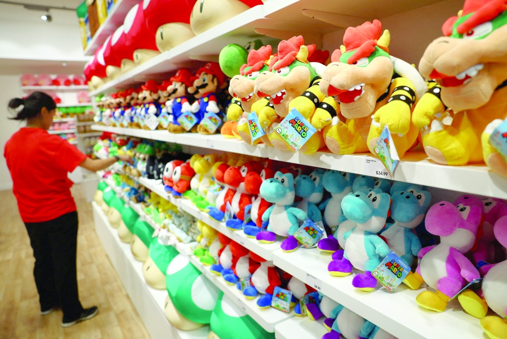 A shop assistant arranges soft toys during a press preview at the Nintendo pop-up store at Westfield London. — Reuters