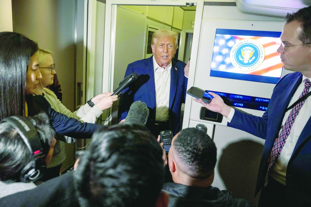 US President Donald Trump speaks to the media aboard Air Force One on the way to Malaysia for the Asean summit. — AFP