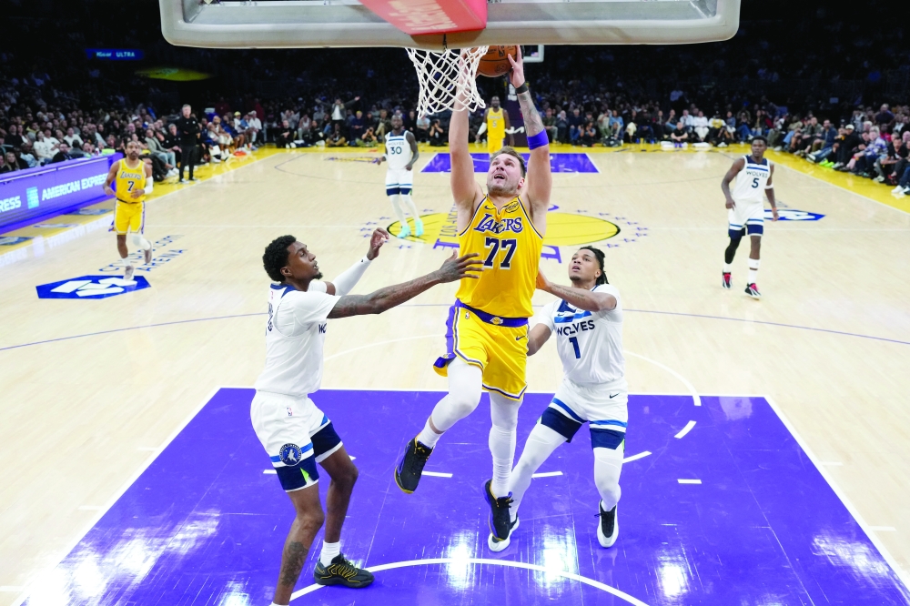  Los Angeles Lakers guard Luka Doncic (77) shoots the ball against Minnesota Timberwolves guard Terrence Shannon Jr. (1) and forward Jaden McDaniels (3). — Imagn Images