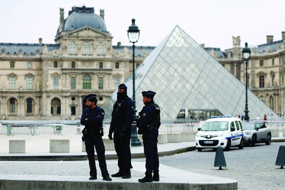 Police stand near the pyramid of the Louvre museum after reports of a robbery in Paris. — Reuters