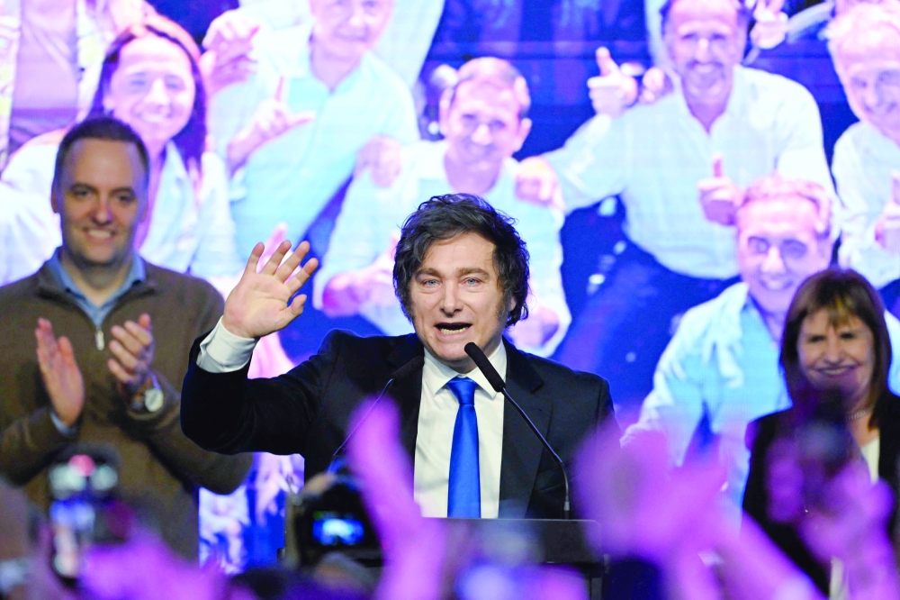 President Javier Milei (C) waves to supporters at the ruling party's La Libertad Avanza headquarters following the results of the national midterm legislative election in Buenos Aires on Monday. — AFP 