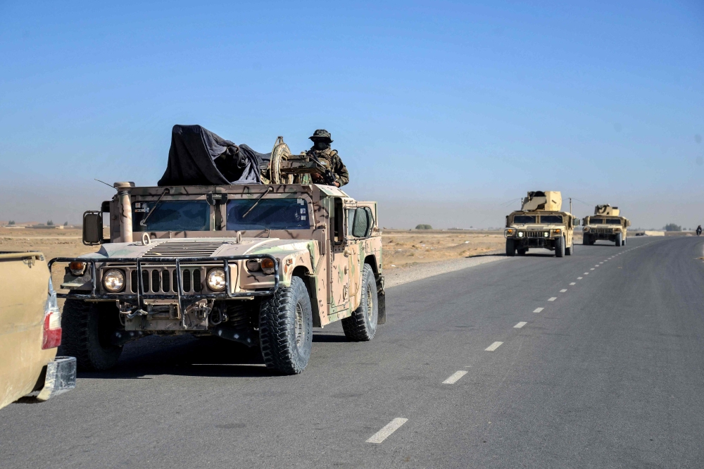 Taliban security personnel patrol on Humvees as they move in a convoy at the Mazal area of the Shorabak district near the Afghanistan-Pakistan border on October 12, 2025.