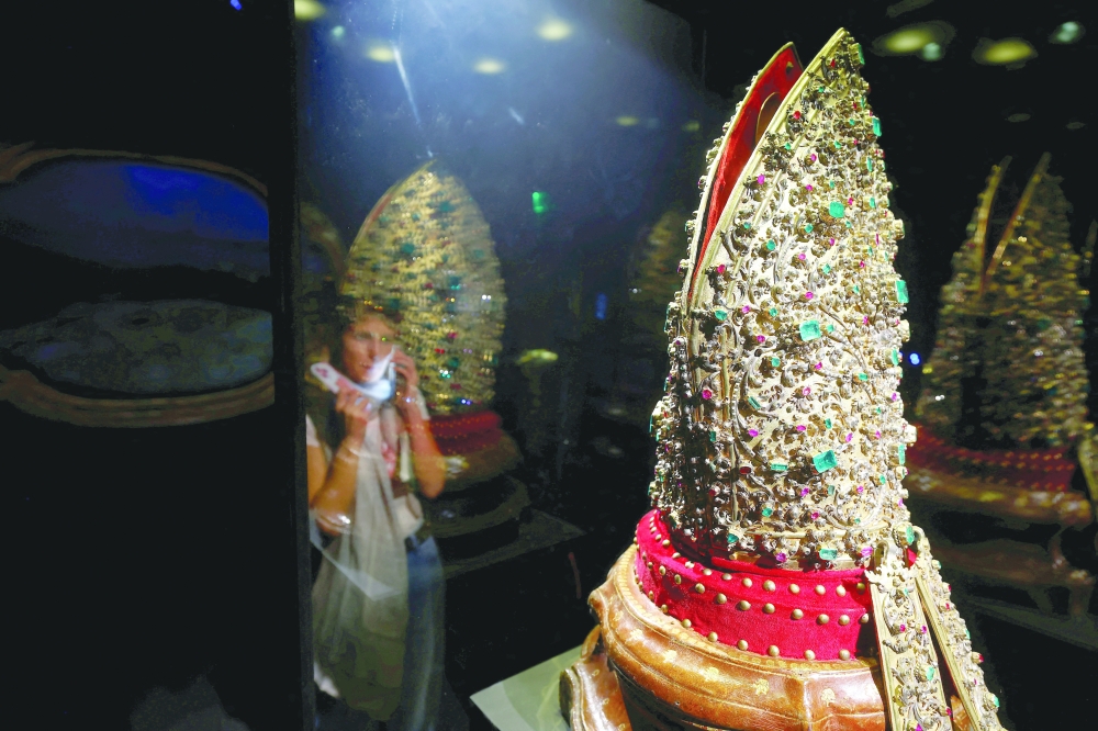 A visitor views a jewelled mitre encrusted with precious stones from the "Treasure of San Gennaro", in Naples. — Reuters