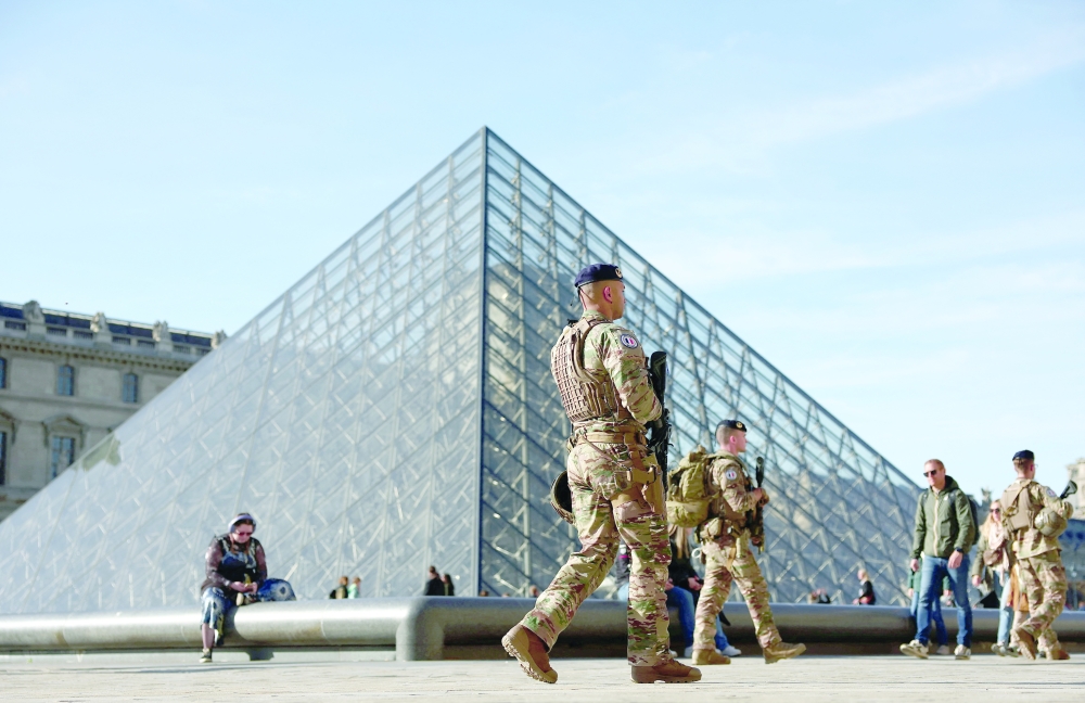 French soldiers from the 'Sentinelle' security plan patrol past the glass Pyramid of the Louvre Museum as French police have arrested more suspects linked to the theft of treasures from the Louvre museum's Galerie d'Apollon in Paris, — Reuters