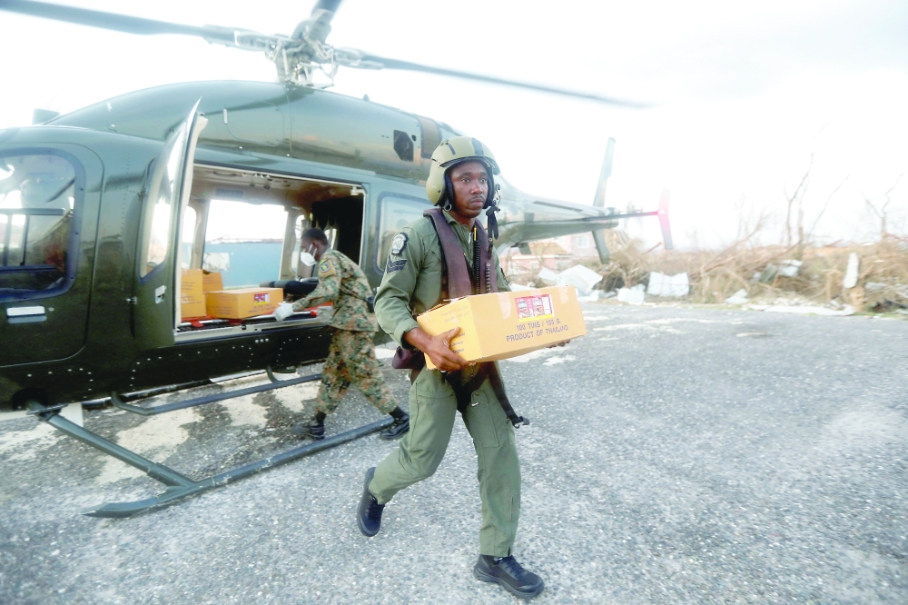 Corporal Andre Williams, of the Jamaican Defence Force, walks away from a helicopter carrying a box with relief supplies, after Hurricane Melissa made landfall in Black River, Jamaica. — Reuters