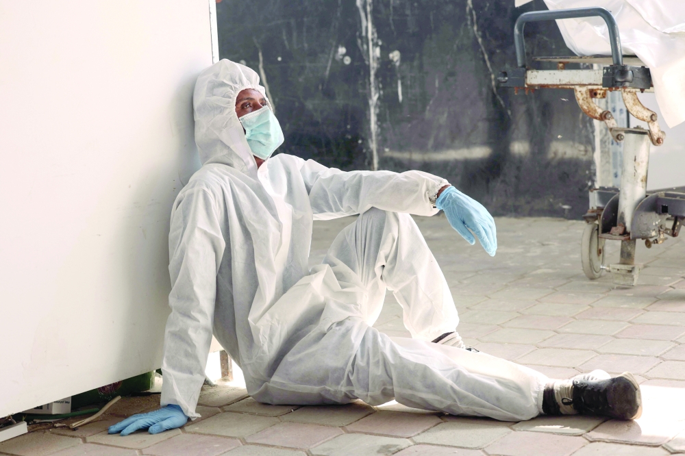 An employee of the Nasser Medical Complex sits on the ground resting after the unloading of body bags containing the thirty corpses of Palestinian prisoners detained by Israel and released as part of the hostage exchange deal, in Khan Yunis on Friday. — AFP