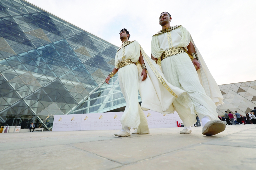 People wearing costumes walk before the official opening of the Grand Egyptian Museum (GEM), near great Giza Pyramids, in Giza, Egypt. — Reuters