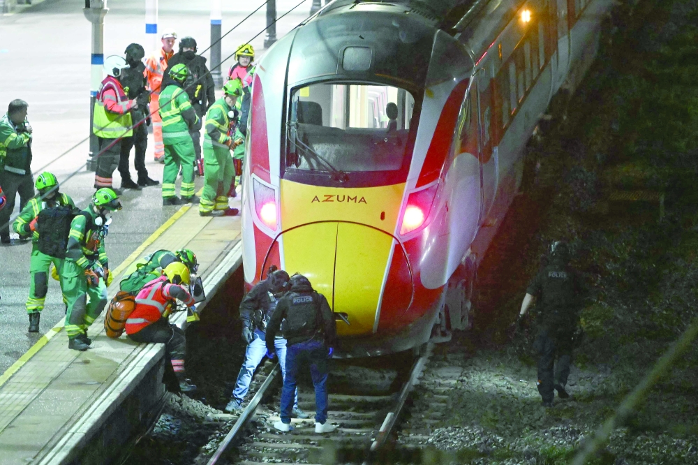 Police officers and members of the Emergency services search the track beneath an LNER Azuma train at Huntingdon Station in Huntingdon, eastern England. — AFP