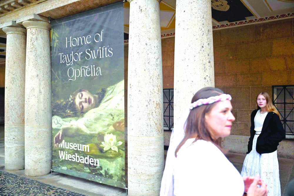 Fans of US singer-songwriter Taylor Swift pose next to a banner with the title 'Home of Taylor Swift's Ophelia' outside the Museum in Wiesbaden, western Germany where the painting 'Ophelia' by German artist Friedrich Heyser is displayed for a short guided tour for the so-called Swifties. - AFP
