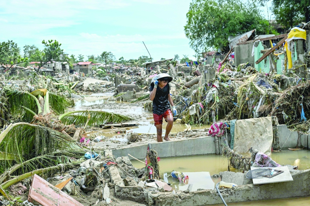 TOPSHOT - A resident walks along damaged houses in the aftermath of Typhoon Kalmaegi in Talisay, in the province of Cebu on November 5, 2025. (Photo by Jam STA ROSA / AFP)

