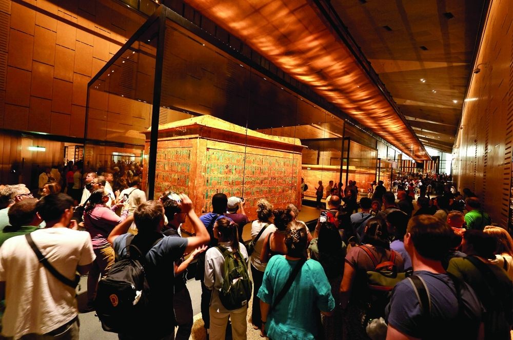 Visitors watch the gallery of ancient Egyptian king Tutankhamun at the Grand Egyptian Museum. 