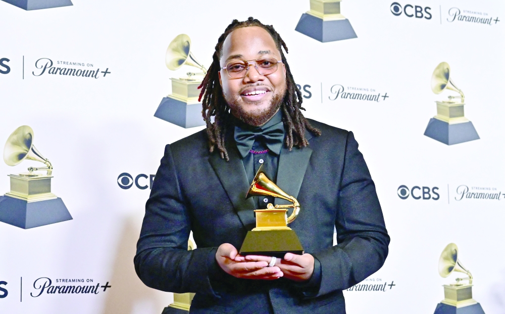 US actor and singer Leon Thomas III poses in the press room with the Grammy for Best R&B Song for 'Snooze' during the 66th Annual Grammy Awards at the Crypto.com Arena in Los Angeles.
