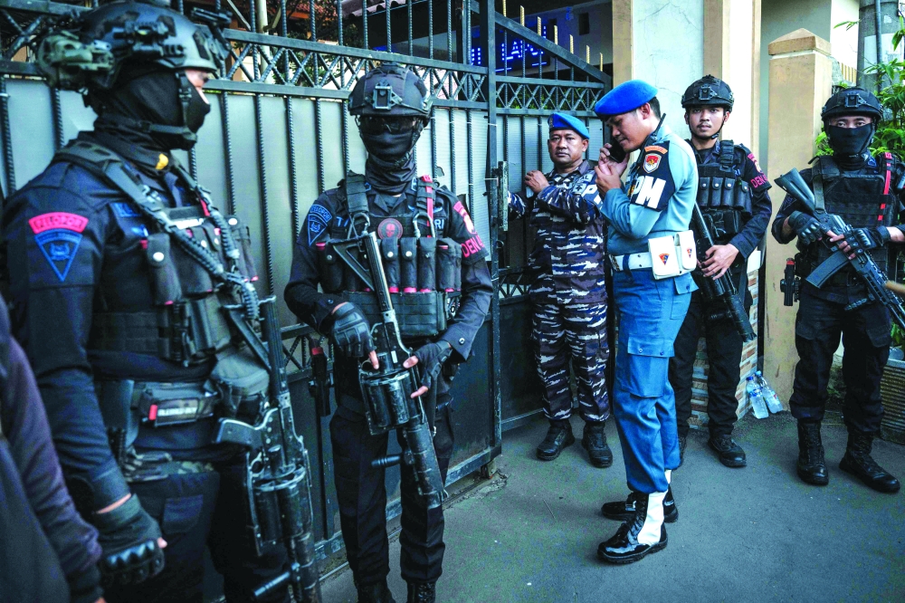 Bomb squad officers stand at the entrance of a school in Jakarta. — AFP