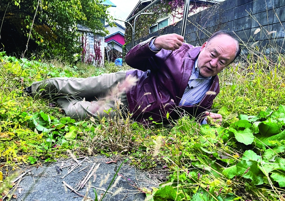 Keiji Minatoya, a confectionery shop owner who was attacked by a black bear in front of the garage in his backyard explains the situation at the time, in Kitaakita, Akita Prefecture. — Reuters