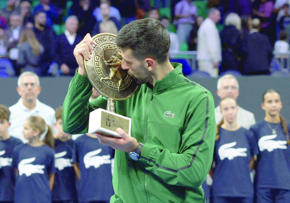 Serbia's Novak Djokovic celebrates with the trophy after winning his final match against Italy's Lorenzo Musetti. — Reuters