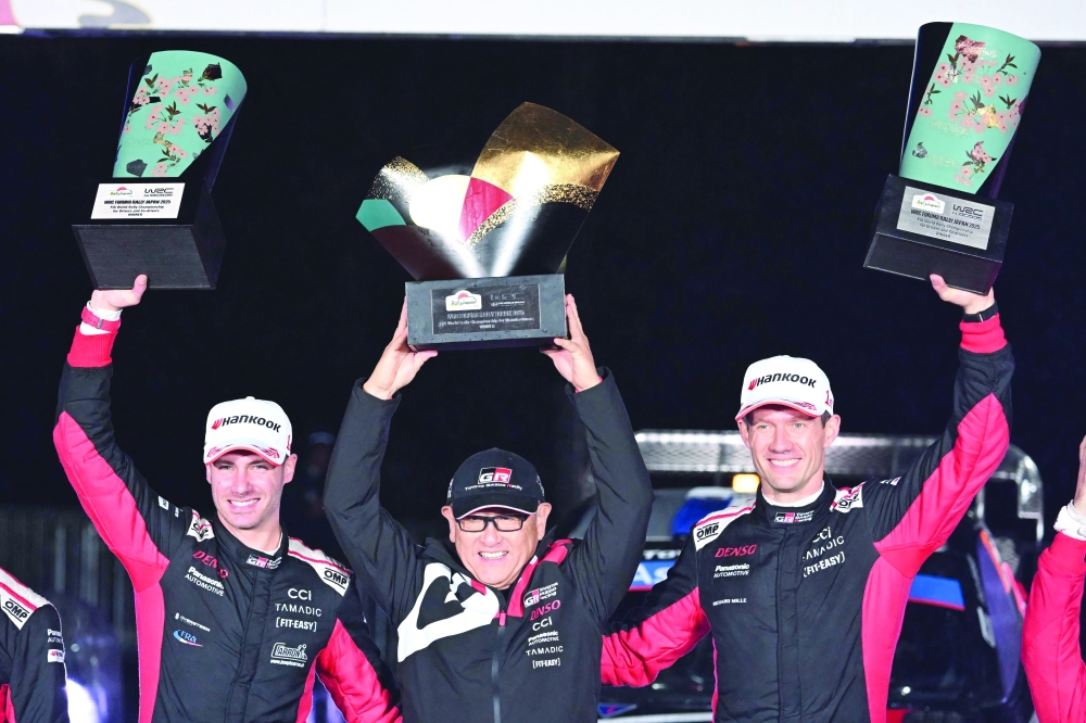 Sebastien Ogier (R) and his co-driver Vincent Landais (L) of France celebrate their victory with Toyota Gazoo Racing chairman Akio Toyoda (C) during the podium ceremony of the Rally Japan. — AFP