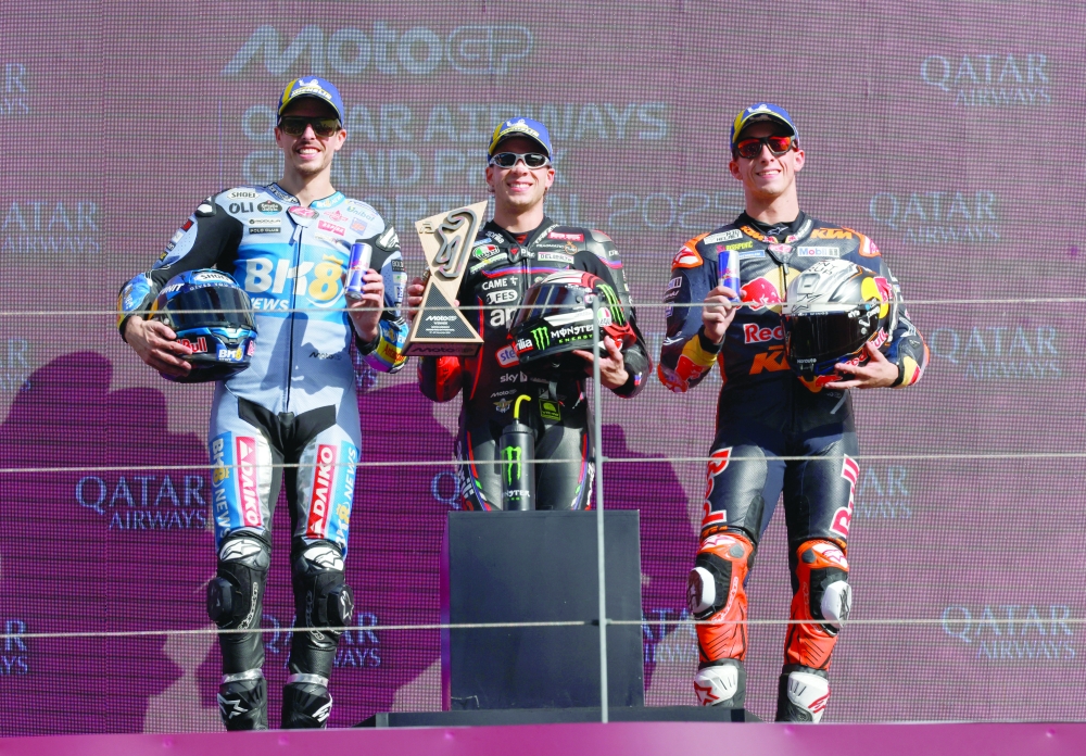 Aprilia Racing's Marco Bezzecchi celebrates on the podium with a trophy after winning the MotoGP race with second placed BK8 Gresini Racing MotoGP's Alex Marquez and third placed Red Bull KTM Factory Racing's Pedro Acosta. — Reuters
