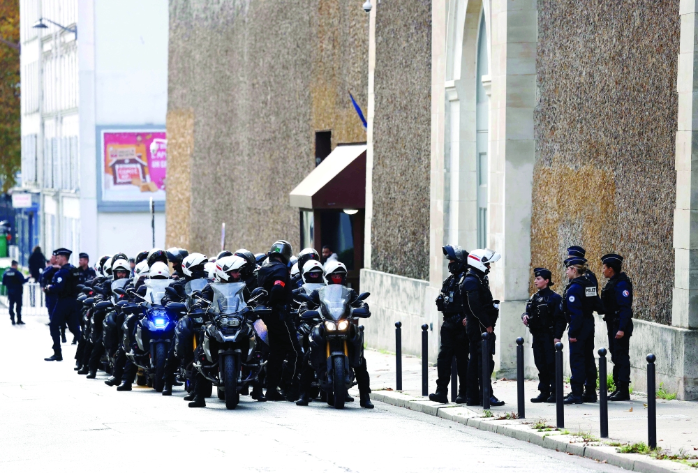 French police officers gather in front of the entrance of the Sante prison in Paris. — AFP