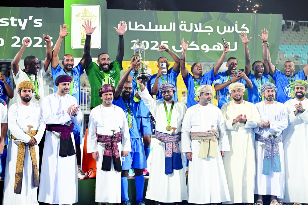 Al Amerat players celebrate with the trophy alongside officials. — Abdulwahid al Hamadani
