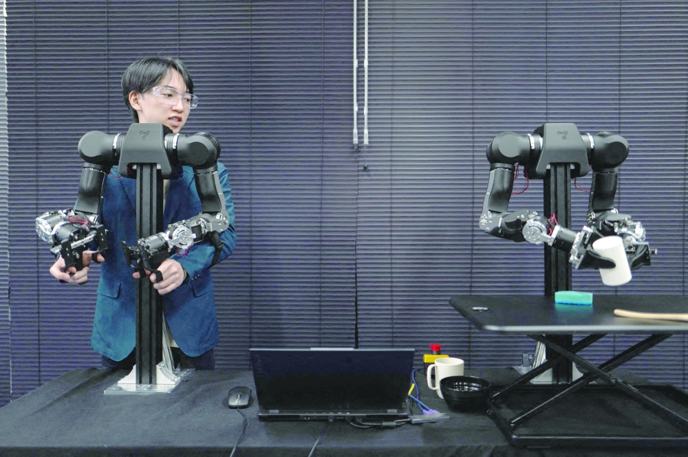 Hiro Yamamoto, CEO of company Enactic, tele-operating an OpenArm humanoid robotic arm at his office in Tokyo.  — AFP