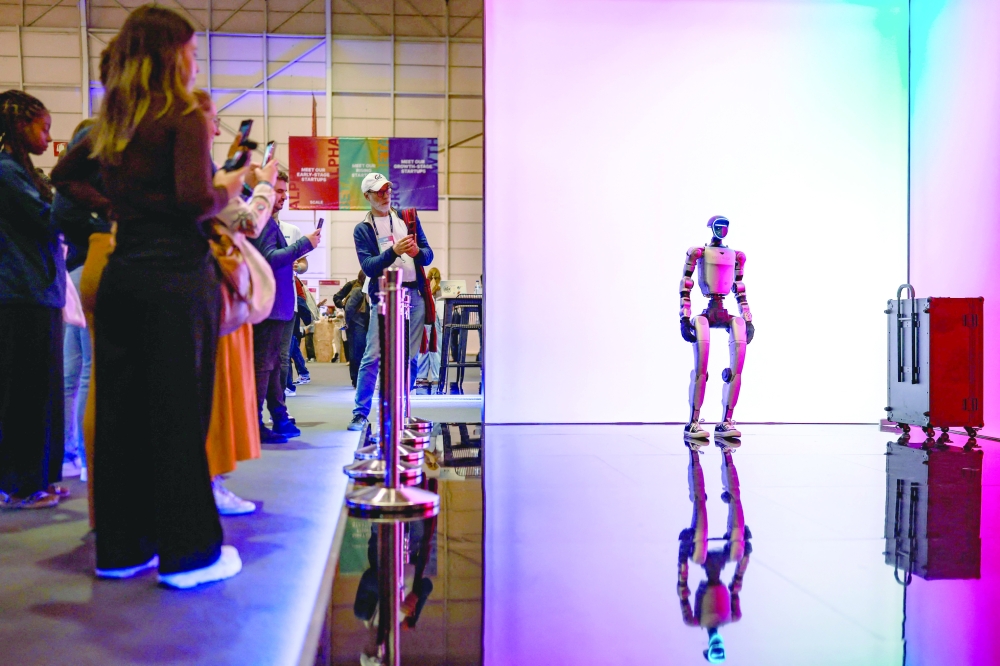 People take pictures of the Unitree robot in Lisbon. — AFP