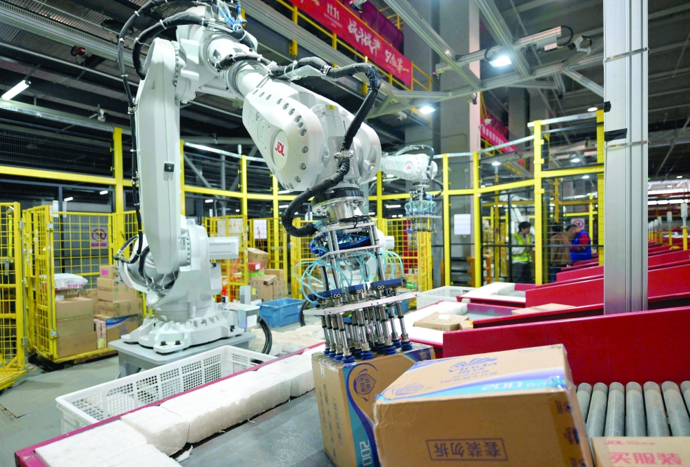 A robot sorts packages at a warehouse in Beijing. — AFP