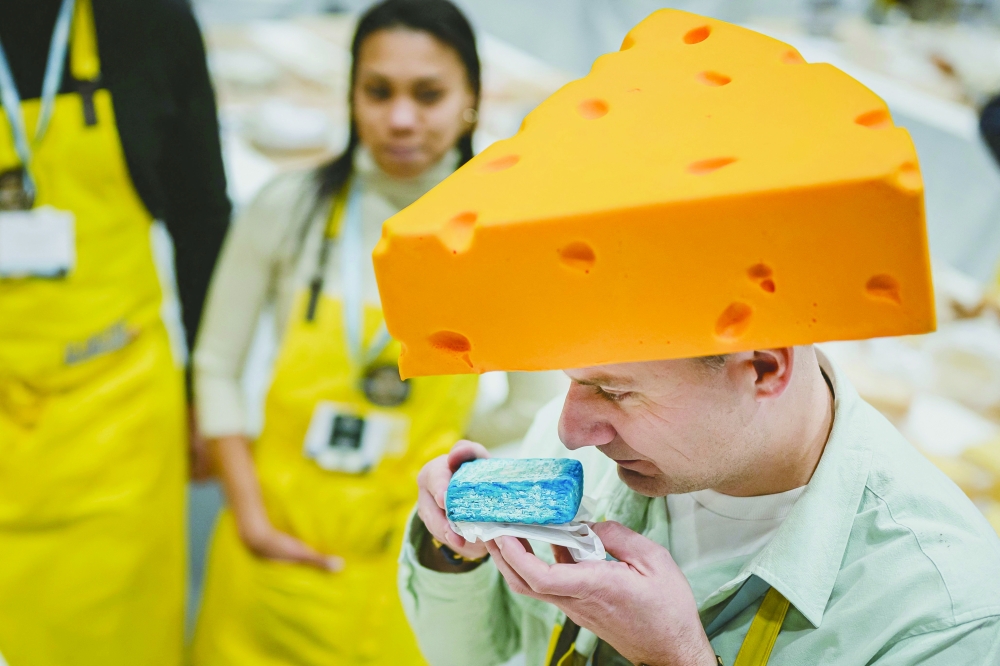 A jury member smells a piece of cheese during the competition. — AFP