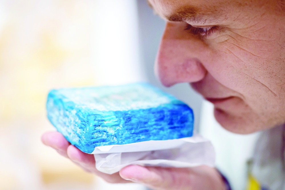 A jury member smells a piece of cheese during the competition. — AFP