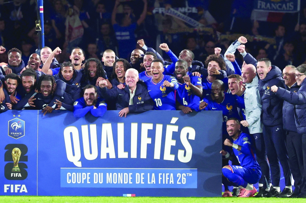 TOPSHOT - France's head coach Didier Deschamps (C) flanked by France's forward #10 Kylian Mbappe (C-R) celebrate with teammates and members of staff after winning the 2026 World Cup qualifiers Europe zone group D football match between France and Ukraine at the Parc des Princes stadium in Paris, on November 13, 2025.  France wins 4 - 0 against Ukraine and qualifies foe the 2026 World Cup. (Photo by FRANCK FIFE / AFP)
