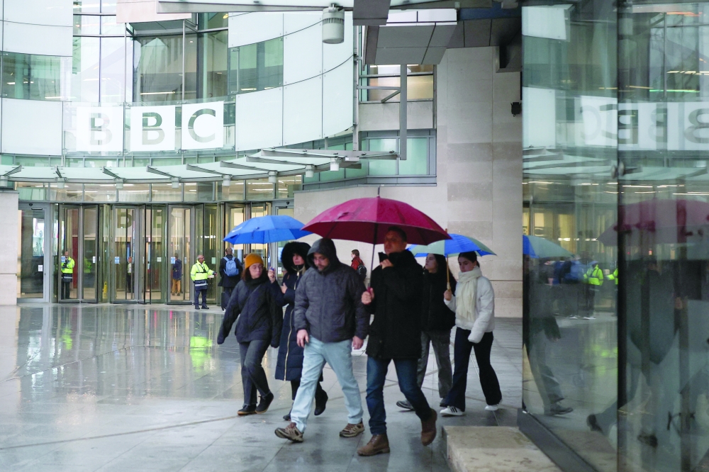 People walk with umbrellas outside BBC Broadcasting House, after Director General Tim Davie and CEO of BBC News Deborah Turness resigned following accusations of bias at the British broadcaster, including in the way it edited a speech by US President Donald Trump in London. — Reuters