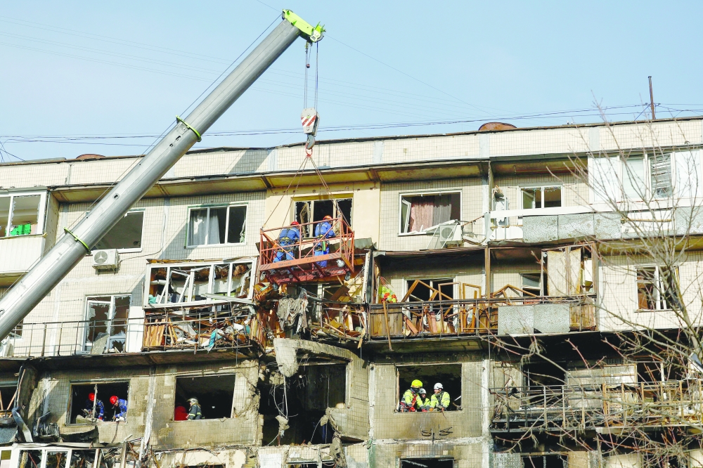 Rescuers work at the site of an apartment building hit during an overnight Russian drone and missile strikes in Kyiv. — Reuters