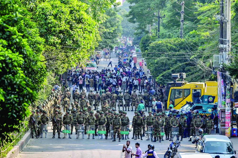 Security personnel stand guard as demonstrators attempt to demolish the residence of Sheikh Mujibur Rahman, in Dhaka. — AFP 