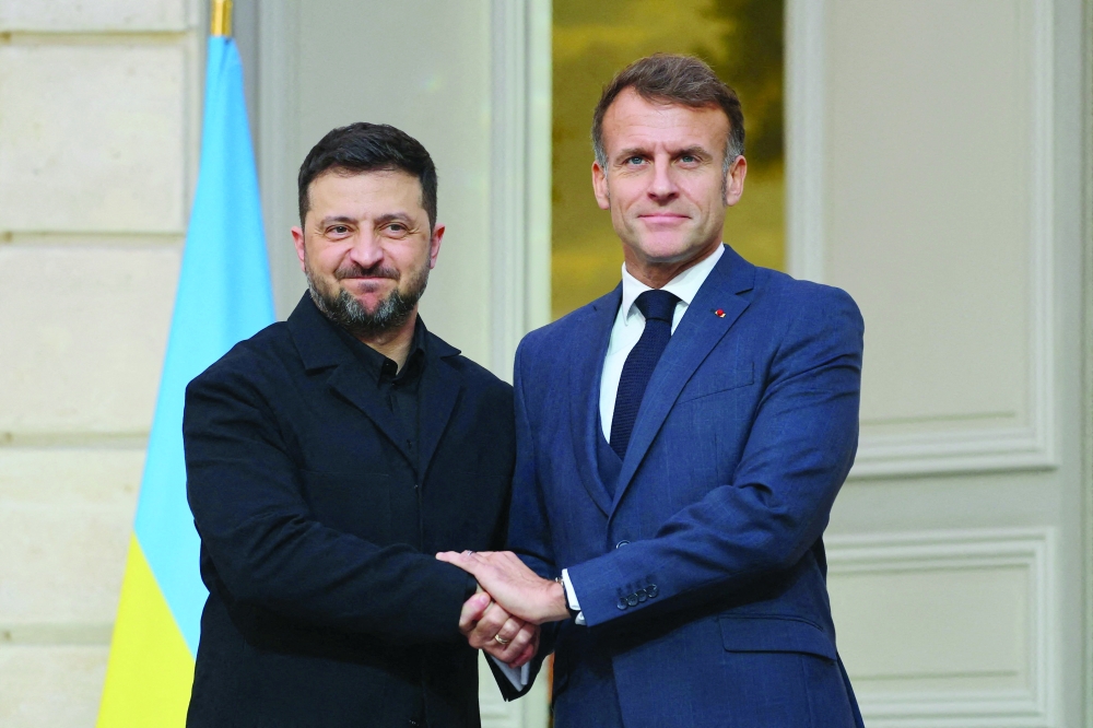 France's President Emmanuel Macron (R) and Ukraine's President Volodymyr Zelensky shake hands, at the Elysee presidential Palace in Paris. — AFP