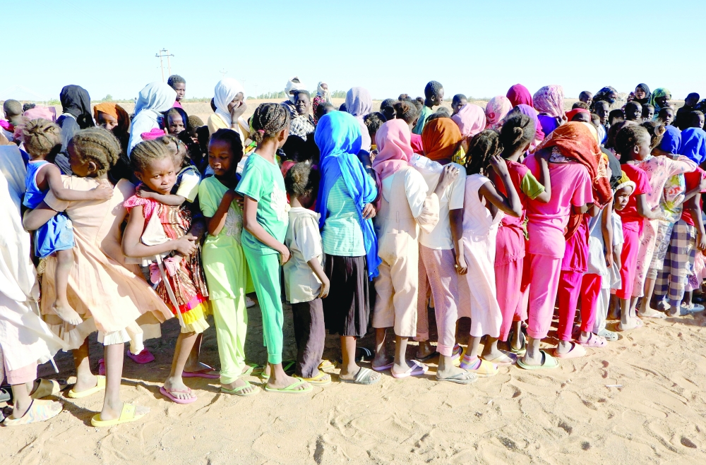 Displaced girls stand in line as they wait for their turn to receive aid, in a displacement camp in Al-Dabbah, Sudan, November 15, 2025. REUTERS/El Tayeb Siddig