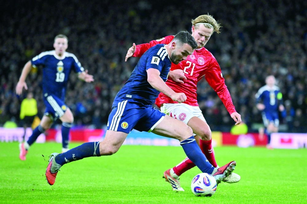 Scotland's midfielder #07 John McGinn vies with Denmark's midfielder #21 Morten Hjulmand during the Fifa World Cup 2026 European qualification football match between Scotland and Denmark at Hampden Park in Glasgow. — AFP