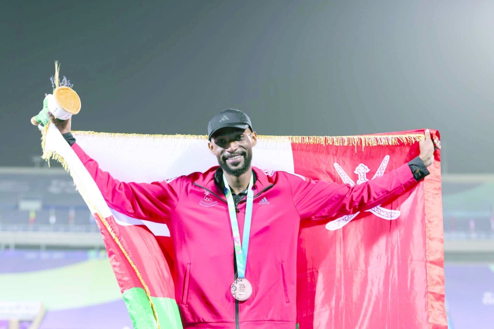 Fatik Beit Jaboob celebrates with the Oman flag.