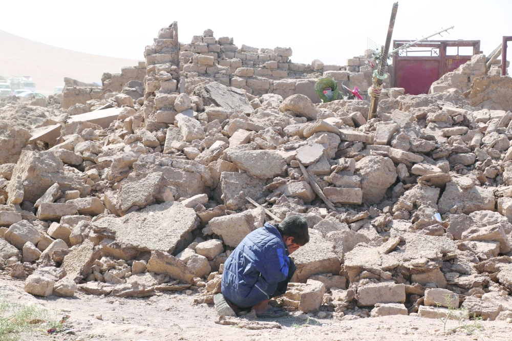 A boy cries as he sits next to debris, in the aftermath of an earthquake in the district of Zinda Jan, Afghanistan. — Reuters file photo 