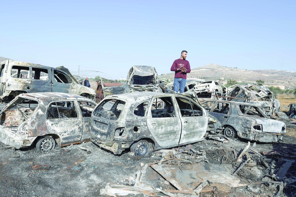 A Palestinian inspects scrap cars burnt in an attack by Israeli settlers, in Huwara, West Bank. — AFP
