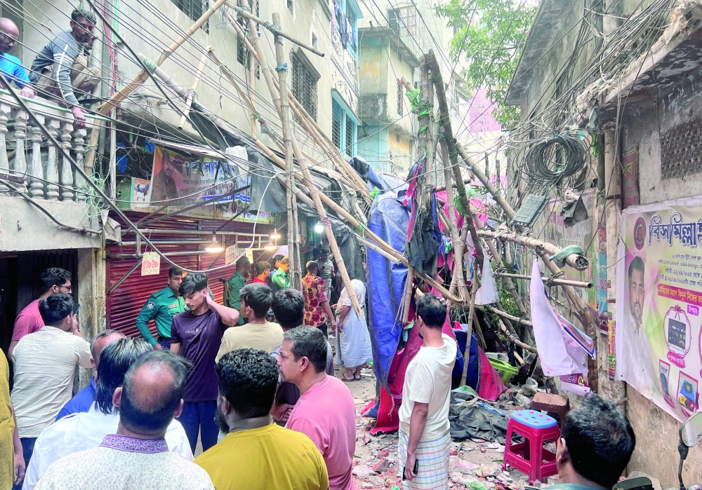 Residents stand in an alley after vacating their house next to a fallen scaffolding following an earthquake in Dhaka, Bangladesh, November 21, 2025. REUTERS/Mohammad Ponir Hossain