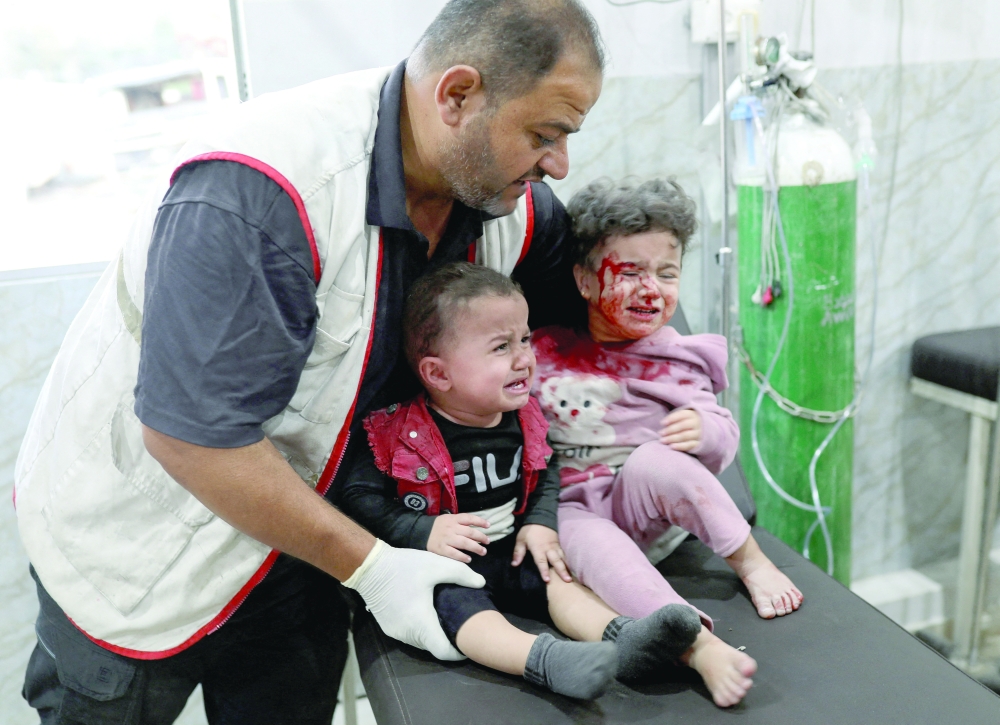 Palestinian children receive medical attention at Al Awda Hospital, following an Israeli air strike, in Gaza City on Saturday. — Reuters