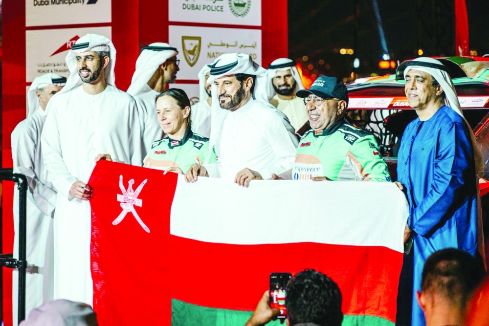 Oman's Hamed al Wahaibi and co-driver with FIA President Mohammed Ben Sulayem after securing the third place in SSV category in the FIA World Baja Cup.