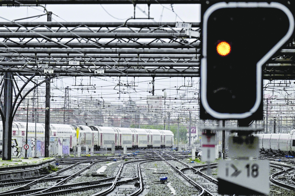 A photograph shows an orange light sign on the railway tracks outside the Gare du Midi - Zuidstation, in Brussels.