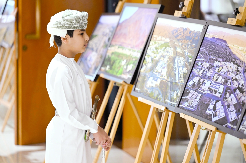 A boy looks at the photographs of the exhibition.