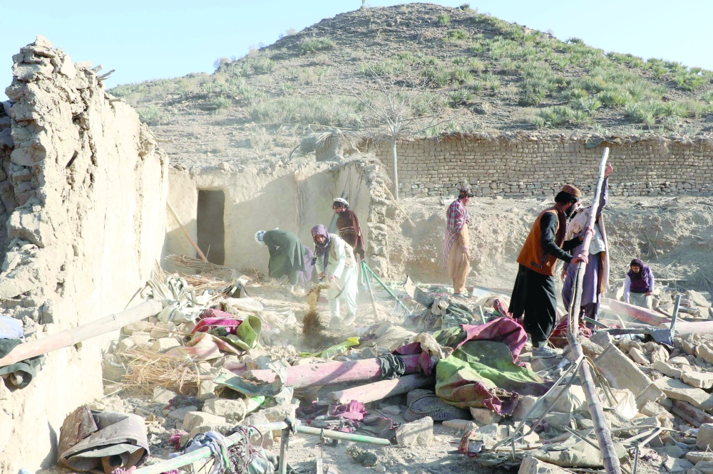 Residents remove debris from a damaged house, in Jige Mughalgai, Khost province. — AFP