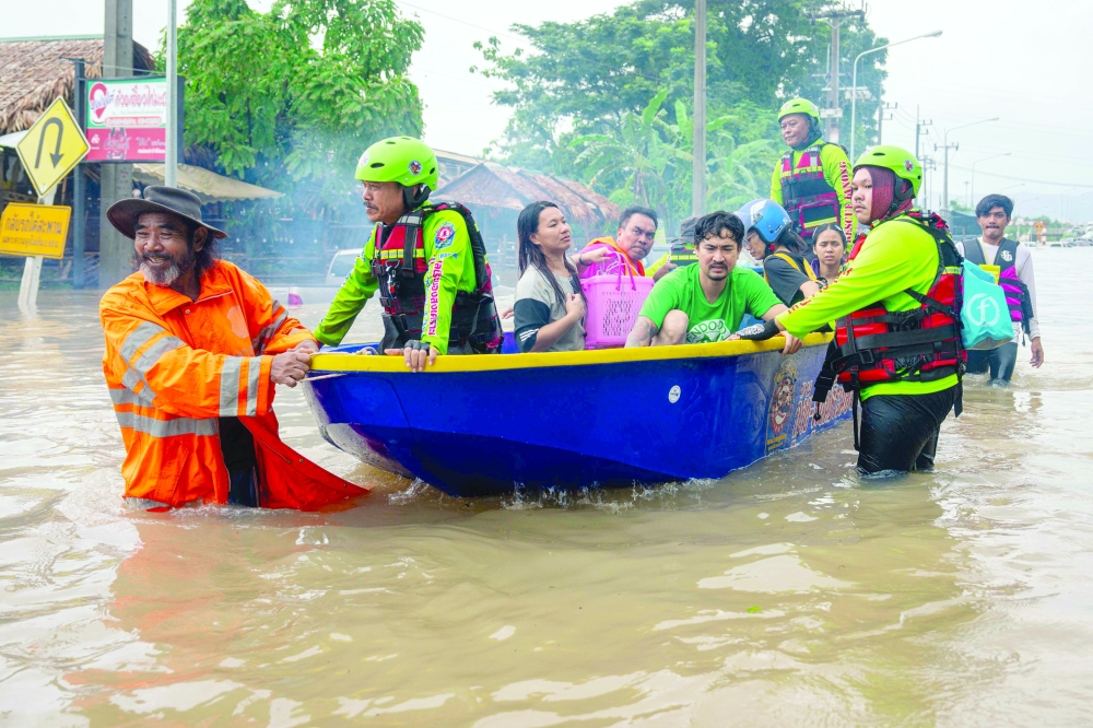 Residents are rescued on a boat in flood waters in Hat Yai in Thailand. — AFP