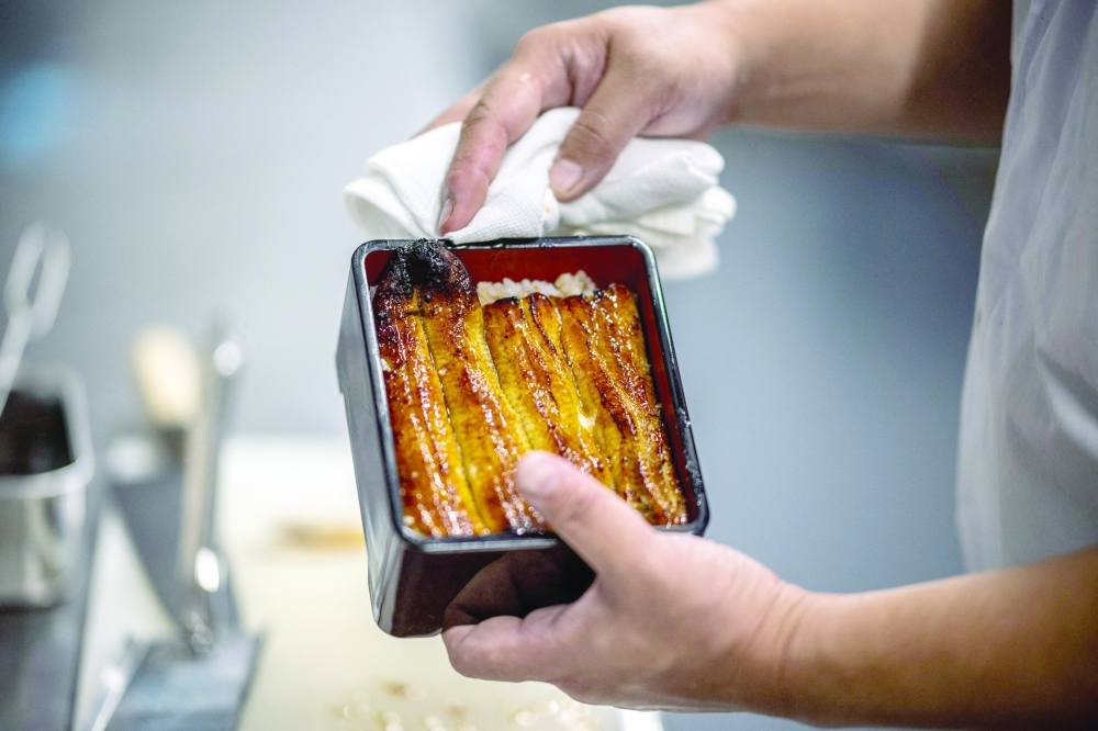 A chef cooks eels in a restaurant of Hiranuma eel farm in Kamisato of Saitama Prefecture. — AFP