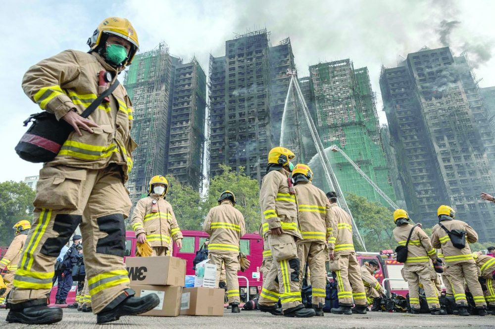 Firemen get ready after a major fire swept through several apartment blocks at the Wang Fuk Court residential estate in Hong Kong's Tai Po district. - AFP