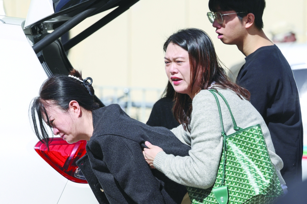 A woman reacts after learning her pet died in the Wang Fuk Court housing estate fire, in Tai Po, Hong Kong. - Reuters