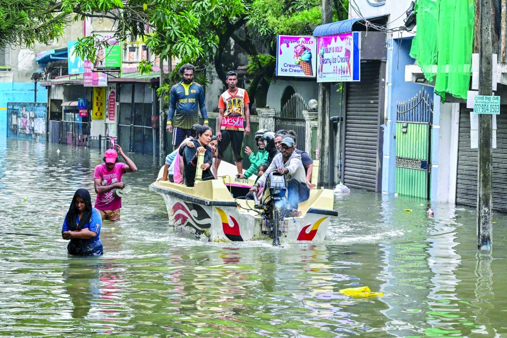 Flood-affected people evacuate after heavy rainfall in Wellampitiya on the outskirts of Colombo. — AFP