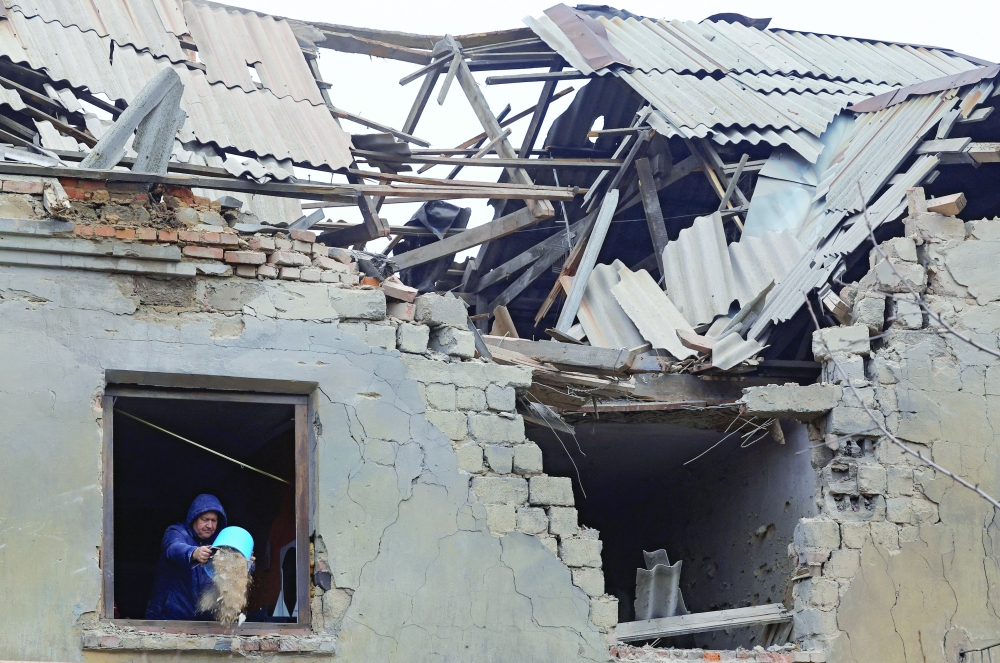 A man clears debris inside his apartment amidst the Russia-Ukraine conflict in Donetsk. — Reuters